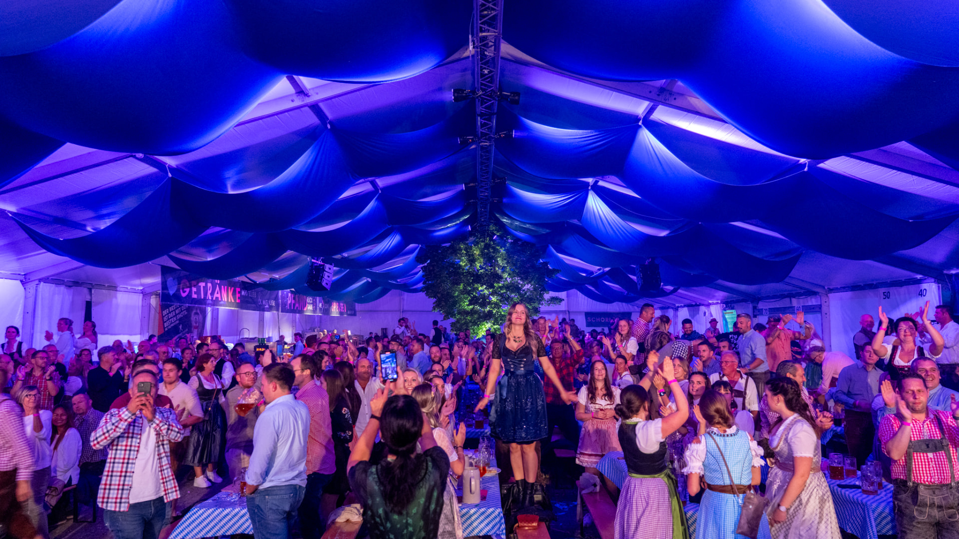 Volles Festzelt beim Oktoberfest Germersheim mit blauer Zeltdecke und feiernden Gästen.
